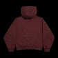 A dark burgundy hooded sweatshirt shown from the back, photographed against a solid black background.