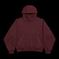 A dark burgundy pullover hoodie with a front kangaroo pocket and subtle tonal side details, displayed against a solid black background.