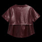 A short-sleeve cropped faux leather top in a deep burgundy color, shown from the back against a solid black background.