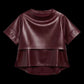 A short-sleeve cropped faux-leather top in a deep burgundy color, featuring a layered asymmetrical hem, displayed against a solid black background.