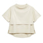 An off-white short-sleeve top with a layered, asymmetrical hem design, displayed on a clean white background.