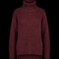A dark burgundy waffle-knit turtleneck sweater displayed against a solid black background.