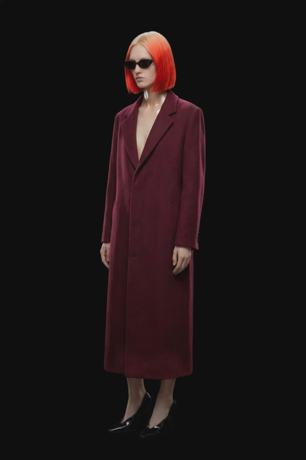 A long burgundy wool-blend coat with notch lapels, front closure, and side pockets, shown against a solid black background.