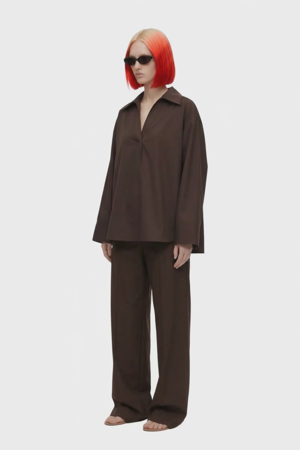 A dark brown long-sleeve collared blouse with a split V-neckline, displayed on a clean white background.