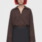 A black midi skirt with a structured waistband and an asymmetrical draped overlay, shown against a plain white background.