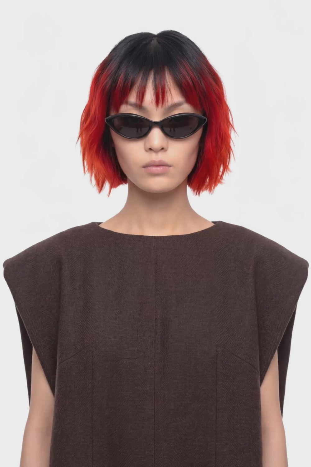 A sleeveless dark brown knit dress with a boat neckline, shown from the back on a plain white background.