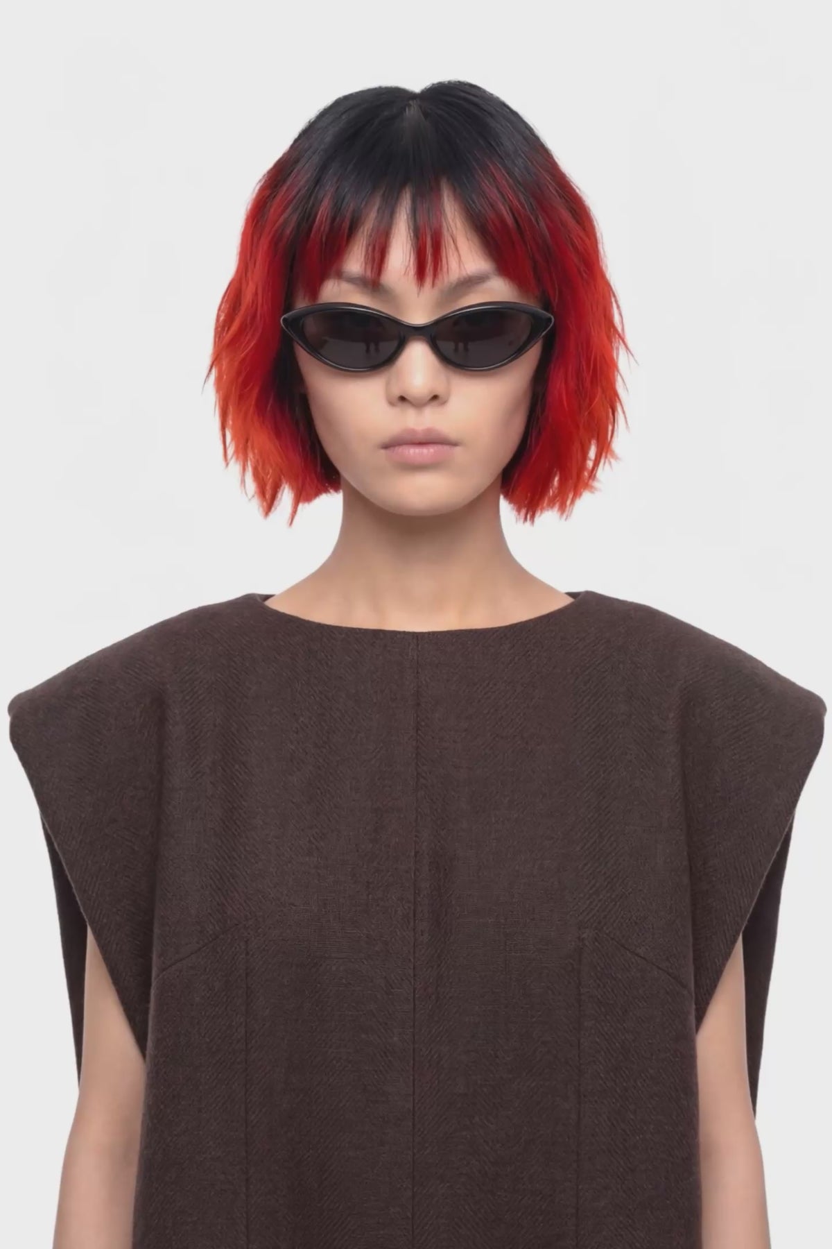 A sleeveless dark brown knit dress with a boat neckline, shown from the back on a plain white background.