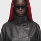 A black leather jacket with a high mock neck, asymmetrical snap button closure, and ribbed sleeve detailing, shown against a plain white background.